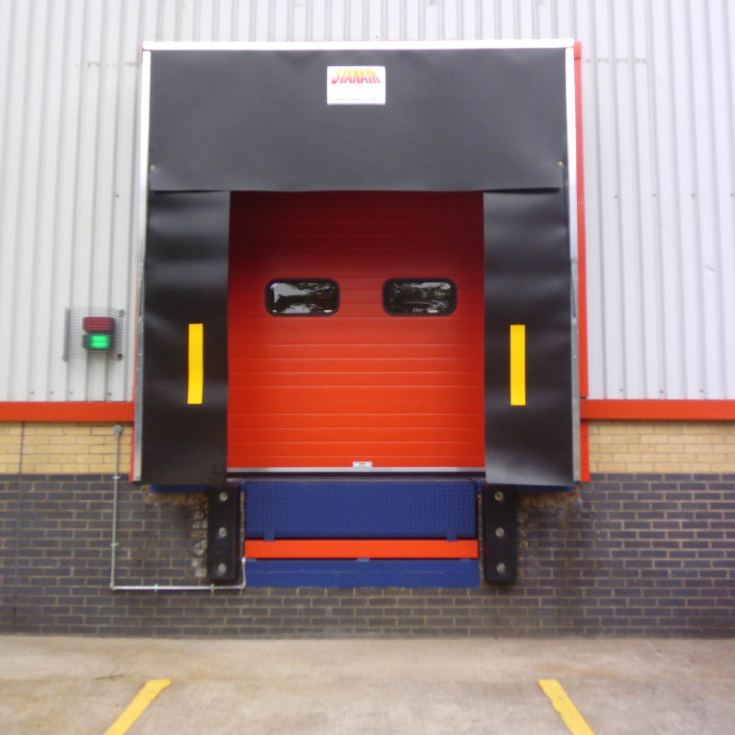 Sectional Overhead door with vision panels alongside Traffic Light System as installed by Stanair Industrial Doors Ltd